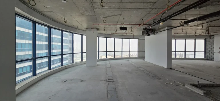 The floor as handed over: bare screed, exposed services and the curved window line